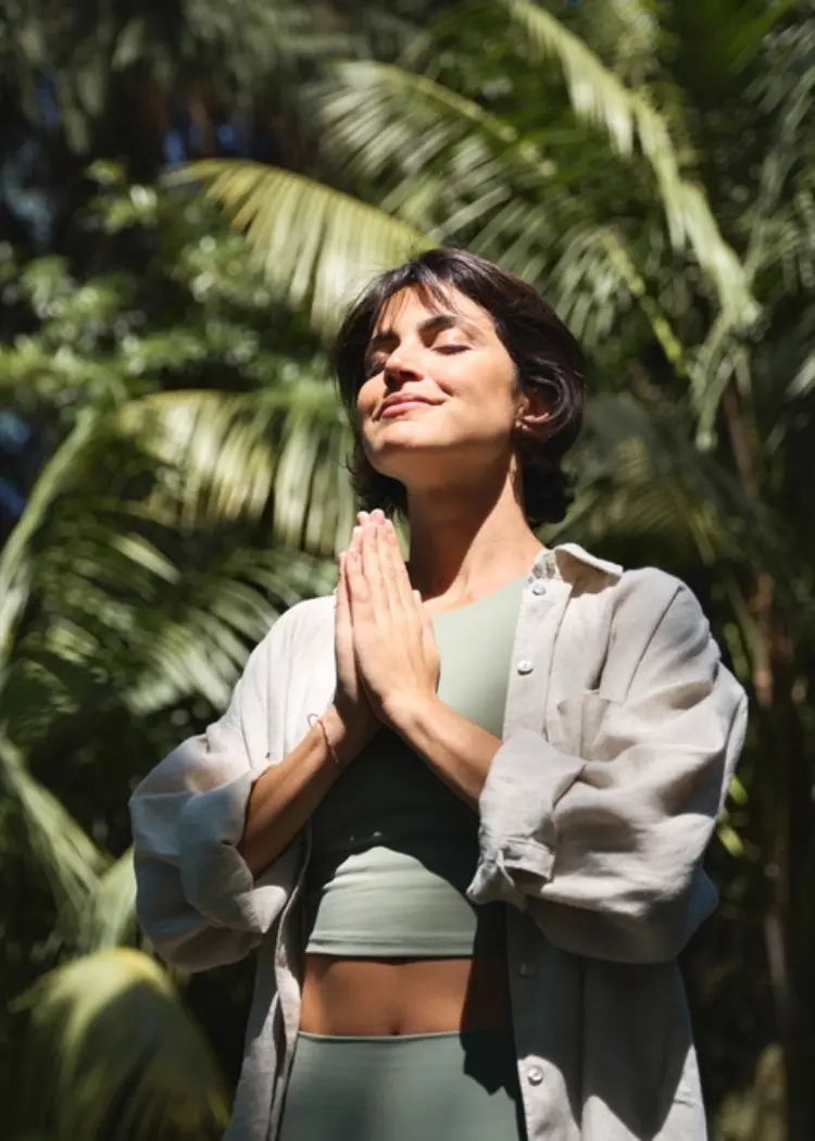 Woman practicing yoga meditation at Swastik, a luxury wellbeing sanctuary near Mumbai and Pune, India.