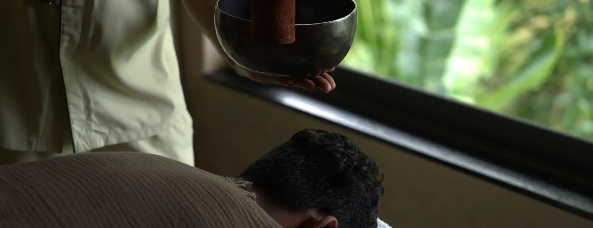 Hands in meditation pose during sunset, embodying holistic detox at Swastik Wellbeing's Ayurvedic programs near Pune.
