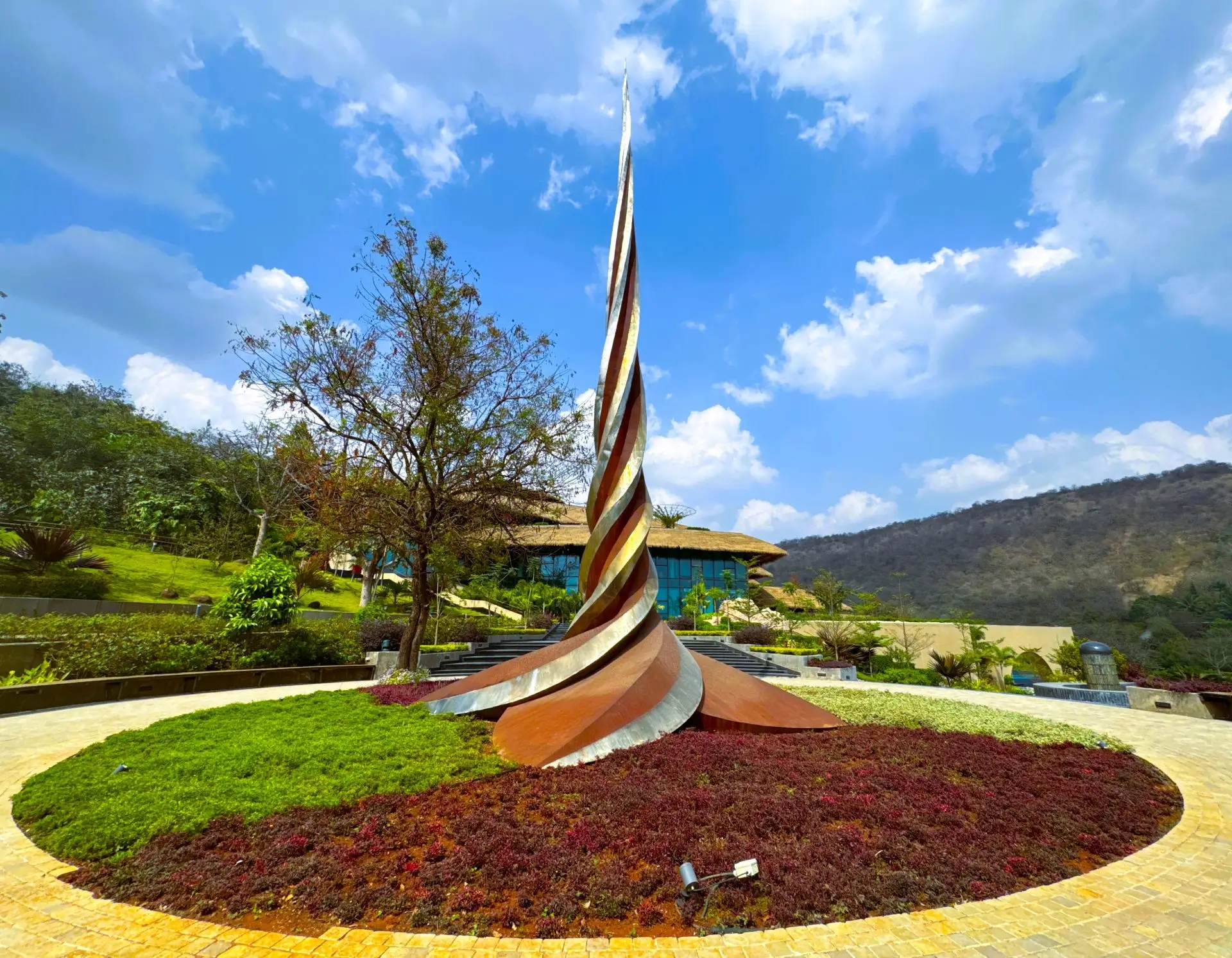 sushumna stambh Sushumna Sthambh sculpture at Swastik Utsav Vihar Pune symbolizing energy points in a wellness retreat setting.