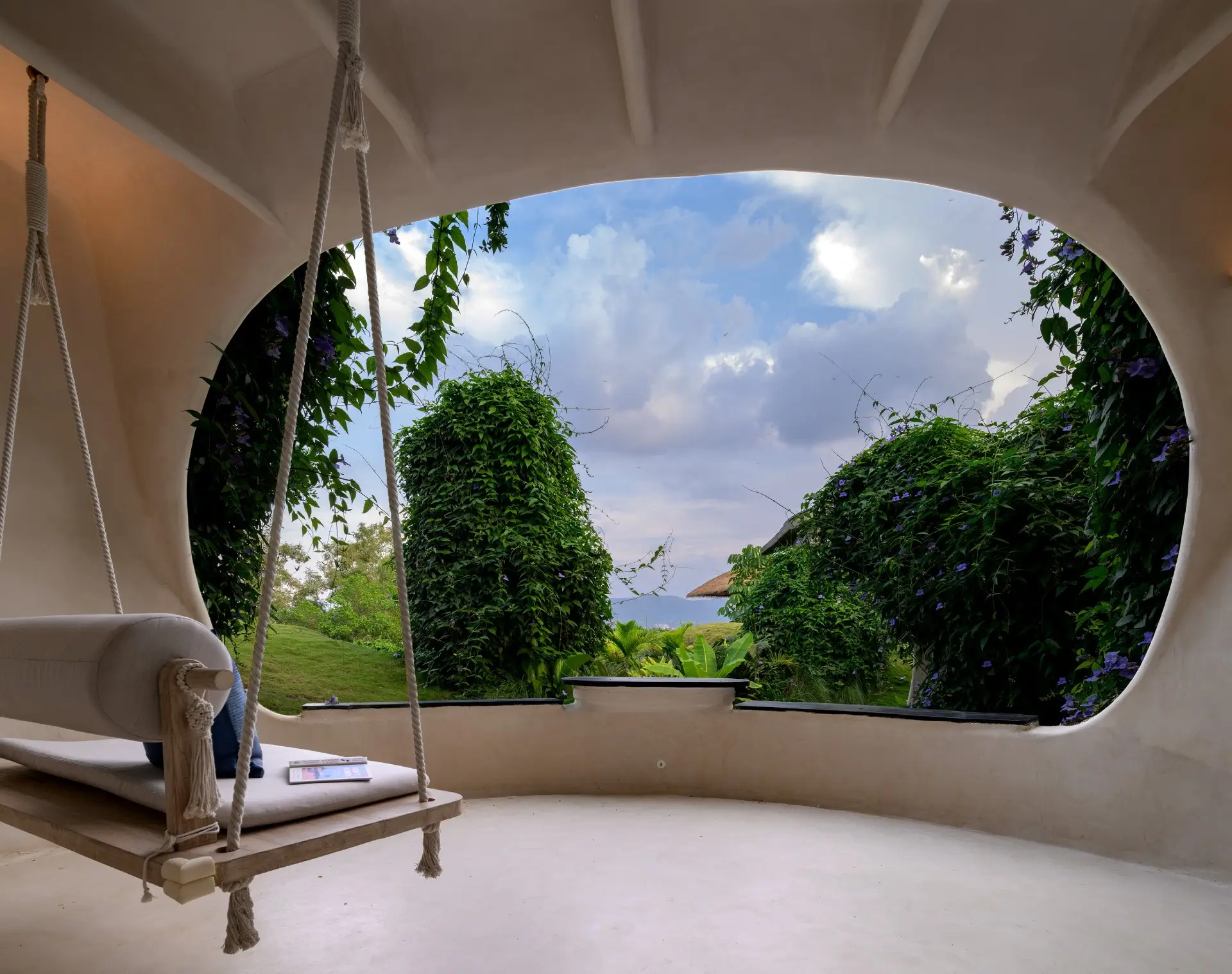 Bhavya Guha sit-out at Sukh Vihar framing valley and lake views through a round window