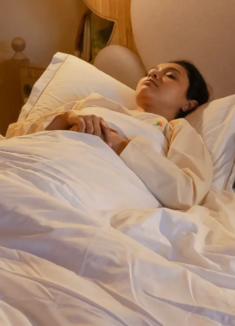 Guest resting in bed in a quiet guest room at Swastik Wellbeing Sanctuary near Pune